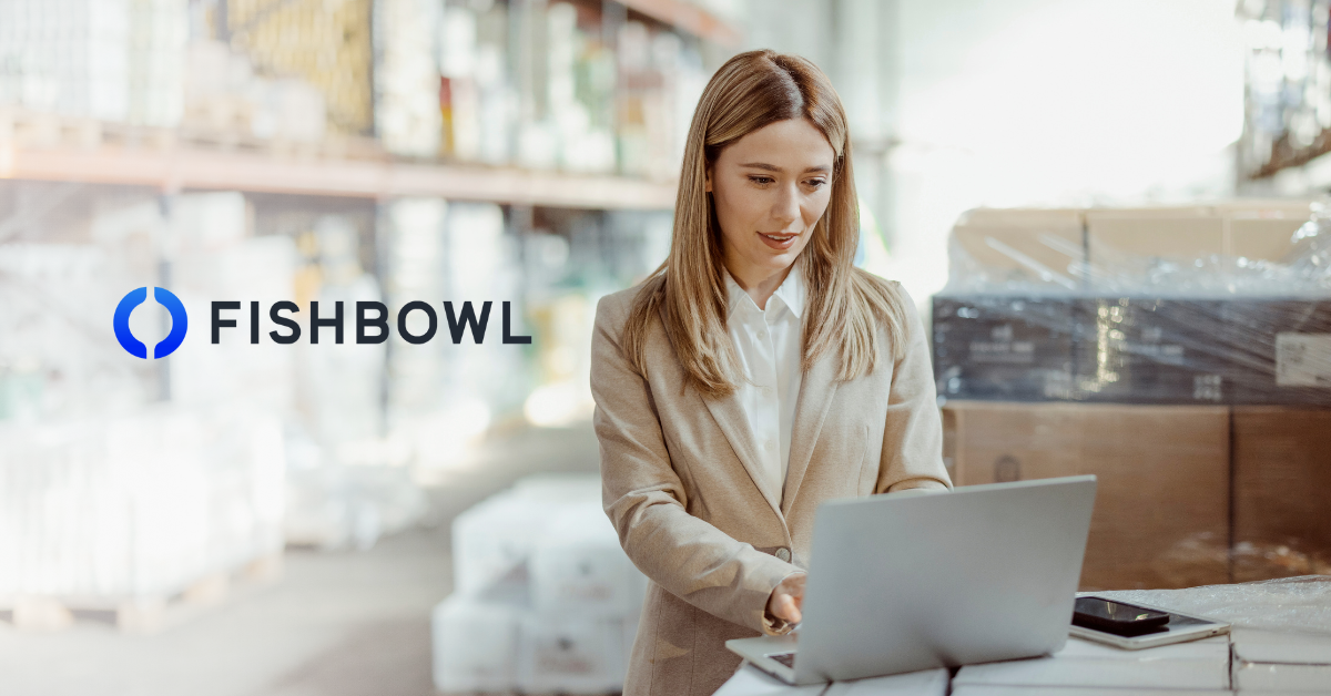Businesswoman looking at computer in warehouse